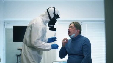 Bir klinik çalışanı koronavirüs salgını sırasında koronavirüs testi yaptırır. Coronavirus, hastahanedeki test sırasında kovid 19 enfekte olmuş hasta..