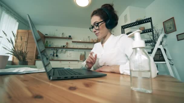 Coronavirus, COVID-19 preventieconcept. Prachtige dame is het reinigen van haar handen tijdens het maken van een videocall — Stockvideo