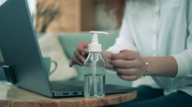 Güzel bayan karantina sırasında evde olduğu için ellerini sterilize ediyor. Coronavirus, COVID-19 önleme kavramı.
