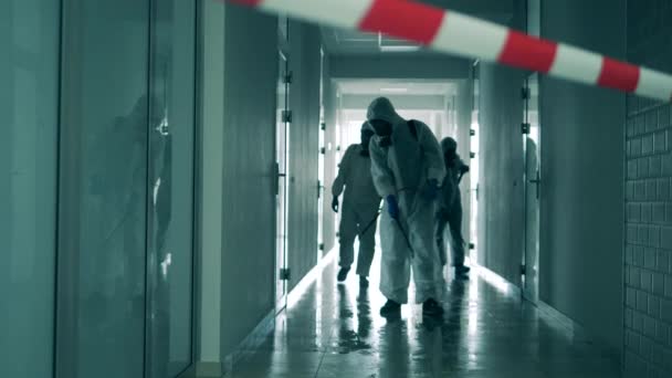 Coronavirus-Pandemie, Virusprävention, COVID-19-Konzept. Desinfektionsexperten dekontaminieren einen Korridor — Stockvideo