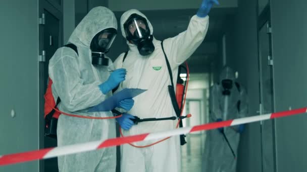 Sanitatie experts praten tijdens desinfectie. Coronaviruspandemie, viruspreventie, COVID-19-concept. — Stockvideo