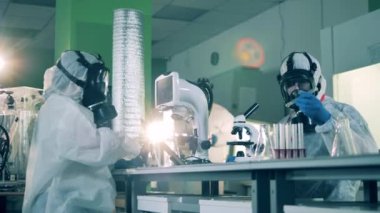 Salgın sırasında üç virüs uzmanı laboratuvar cihazlarıyla çalışıyor..