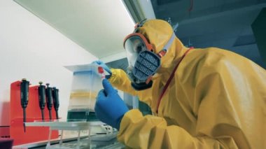 Bir araştırmacı laboratuvarda çalışırken koronavirüs testini kontrol eder.