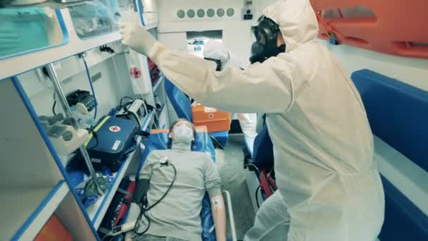 Un patient dans l'ambulance avec des médecins en combinaison. Coronavirus, concept COVID-19 . — Video