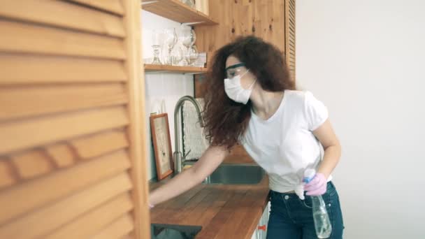 A girl uses sanitizer while cleaning house during quarantine. — Stock Video