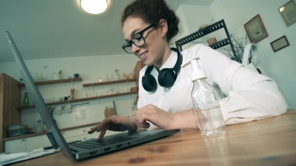 Trabajador utiliza desinfectante de manos mientras escribe en un ordenador portátil . — Vídeos de Stock