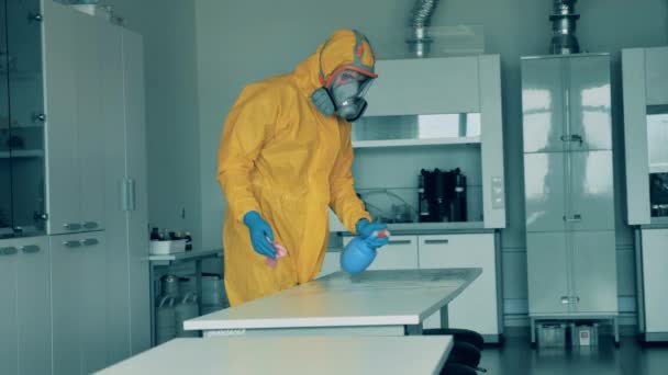 Trabajador de saneamiento limpia una mesa, matando virus durante pandemia . — Vídeos de Stock