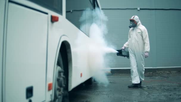 Bus buitenkant wordt ontsmet door een sanitair expert — Stockvideo