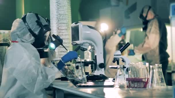 При разработке вакцины люди работают с микроскопами в лаборатории . — стоковое видео