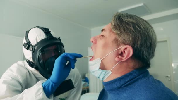 コロナウイルスのパンデミック、 2019-ncov 、コロナウイルスの概念。医療従事者の高齢患者の喉の検査 — ストック動画