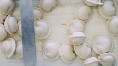 Taşıyıcı boyunca hareket eden ve oradan düşen hamur köftelerinin üst görüntüsü
