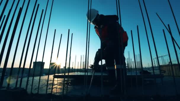 Openluchtgebouw met een mannelijke arbeider die beton vernielt — Stockvideo