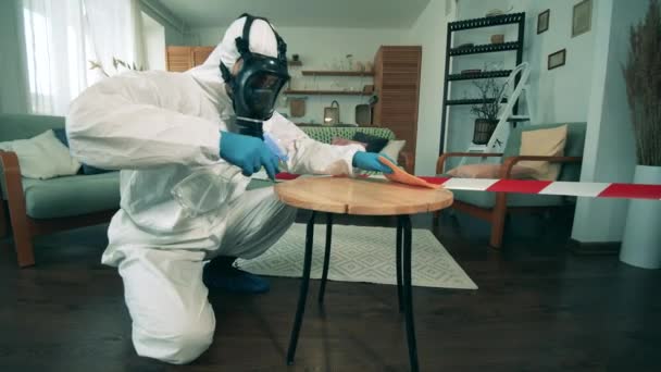 Um homem de hazmat limpa a mesa com desinfetante. Desinfetante antibacteriano usado durante a pandemia de 19 dias . — Vídeo de Stock