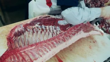 Kaburgalı büyük bir et parçası fabrikada kesiliyor. Gıda üretimi, et, domuz üretim fabrikası.