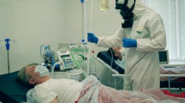 Paramedikler erkek bir hastaya tıbbi serum enjekte ediyor. Coronavirus, kovid 19 hastası bir hastanede yoğun bakımda..