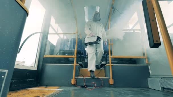 L'ispettore sanitario sta usando un fumigatore per disinfettare un autobus — Video Stock