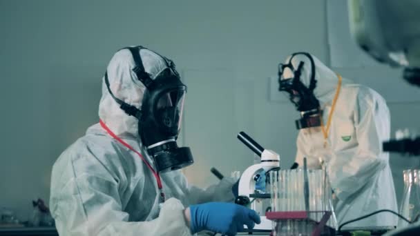 Researchers in hazmats work in laboratory, developing a covid-19 vaccine. — Stock Video