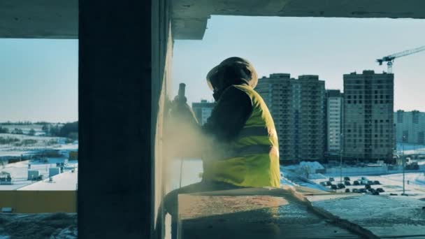 Vista lateral de una pared de cemento siendo pulido por un trabajador masculino — Vídeo de stock