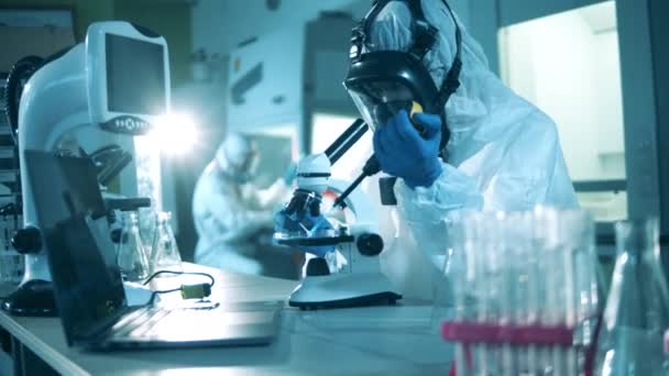 Lékařský výzkum protilátek proti COVID-19. Laboratorní výzkumník pracuje s mikroskopem — Stock video