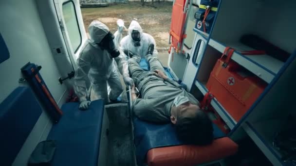 Ambulans çalışanları arabadaki erkek hastayla ilgileniyorlar.. — Stok video