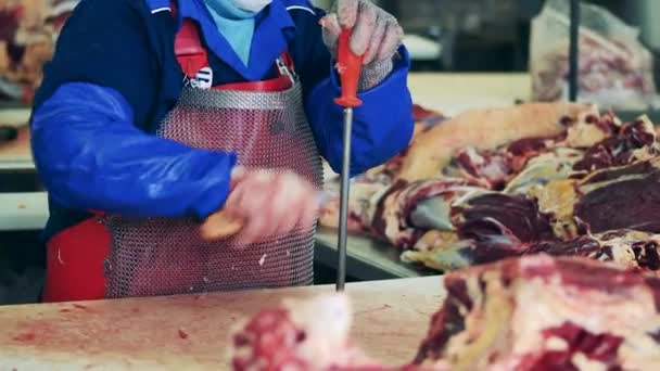 Работник скотобойни точит нож — стоковое видео