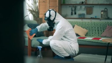 Adam bir odadaki mobilyaları temizlemek için dezenfektan kullanıyor. Covid19, Coronavirus önleme kavramı.