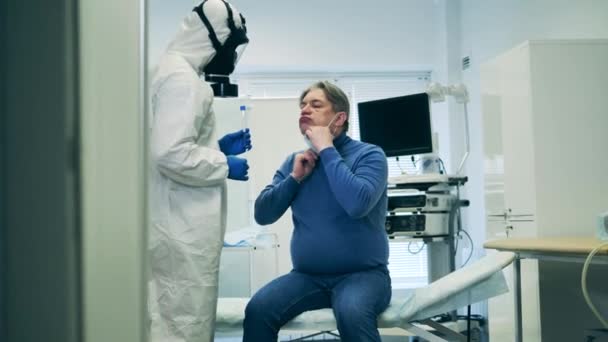 Старшему мужчине делают анализ слюны. Пандемия коронавируса, 2019-нков, концепция коронавируса . — стоковое видео