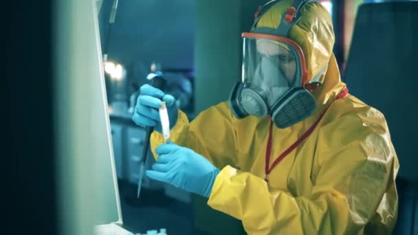Specialista in una tuta hazmat sta lavorando con una provetta. Ricerca anticorpi cocnept, covid-19 pandemia coronavirus . — Video Stock