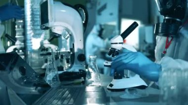 Laboratuvar uzmanları örnekleri mikroskop altında inceliyorlar. Antikorlar araştırması cocnept, covid-19 koronavirüs salgını.