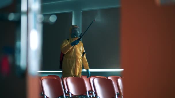 Sanitär expert sprutar kemikalier i publikhallen — Stockvideo