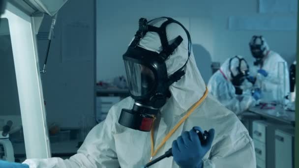Przeciwciała badają koknept, covid-19 pandemię koronawirusową. Ekspert w kombinezonie obserwuje próbkę biochemiczną. — Wideo stockowe