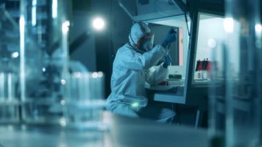 Kişi laboratuarda test tüpleriyle çalışır..