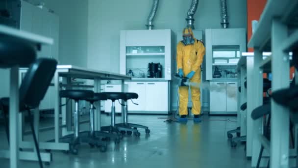 Trabalhador de saneamento usa máquina de pulverização para matar vírus na sala . — Vídeo de Stock