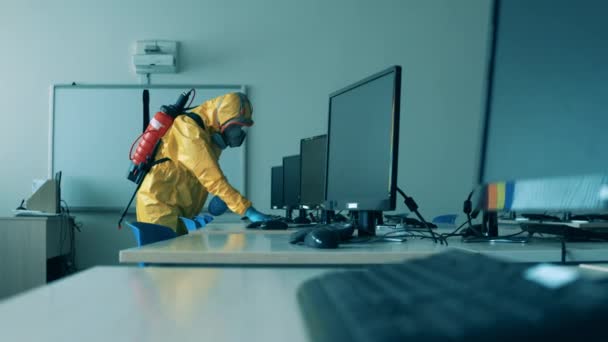 İşçi virüsü öldürmek için masaları monitörlerle temizliyor. — Stok video