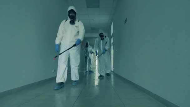 Άνδρες εργαζόμενοι απολυμαίνουν ένα διάδρομο ενός κτιρίου γραφείων. — Αρχείο Βίντεο