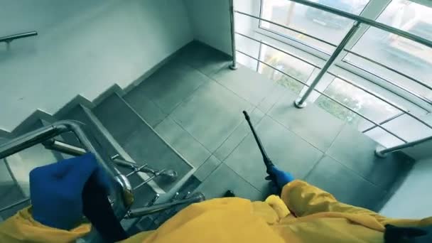 Один человек распыляет лестницу во время дезинфекции . — стоковое видео