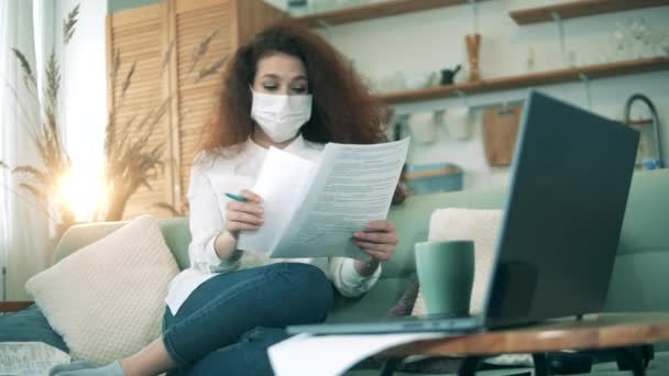 Vrouwelijke werknemer controleert documenten tijdens het verblijf thuis tijdens quarantaine, werken vanuit huis concept. — Stockvideo