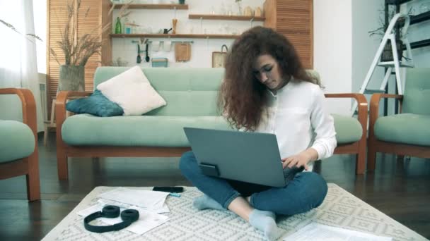 Una mujer trabaja con un portátil que se queda en casa durante la pandemia. Concepto de trabajo remoto . — Vídeos de Stock