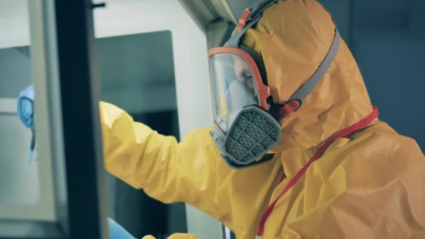 Expert in een hazmat pak analyseert biologische substantie — Stockvideo