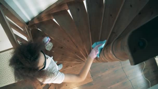 Mladá žena utírá schody dezinfekčním prostředkem během karantény. — Stock video
