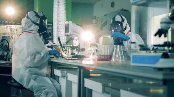 A laboratóriumi dolgozók egy csoportja tudományos kutatást végez — Stock videók