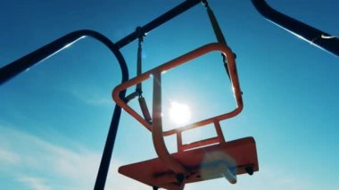 Güneş ışığı boş salıncaklarda parlıyor.