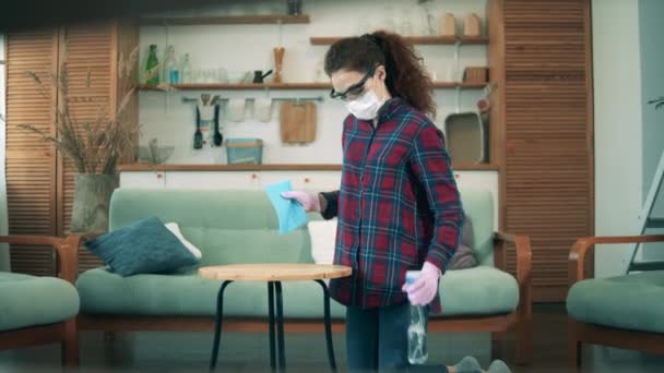 Jeune femme nettoie une table tout en restant à la maison pendant le confinement covid 19 . — Video