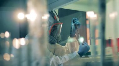 Laboratuvar birimi ve bir bilim adamı tüplerde numune test ediyorlar.