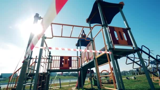 Warnband um einen leeren Spielplatz gewickelt. Covid-19-Ausbruch, Coronavirus Lockdown-Konzept. — Stockvideo