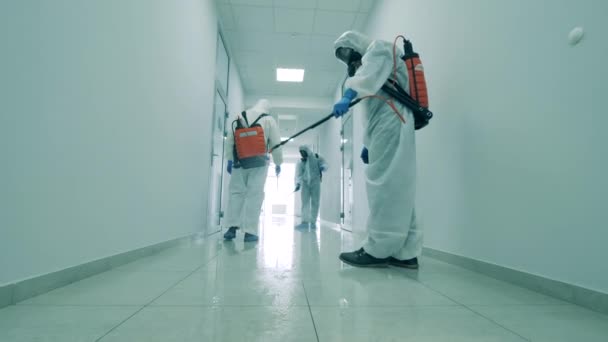 사무실 건물에서 코로나 바이러스를 죽이기 위해 청소하는 사람들 이 복도를 소독 한다. — 비디오