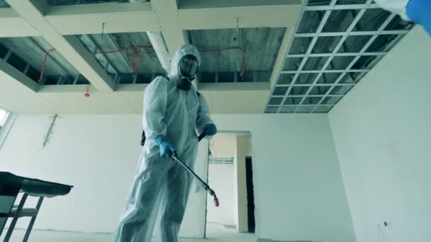 Desinfectoren sproeikamers in onvoltooide gebouwen tijdens een coronaviruspandemie. — Stockvideo