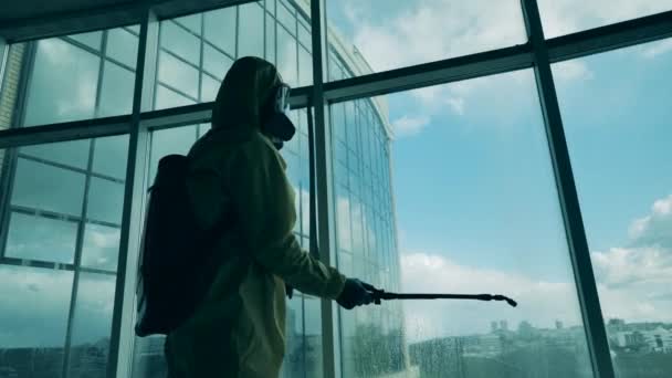 Trabajador sanitario rocía ventanas en un edificio . — Vídeos de Stock