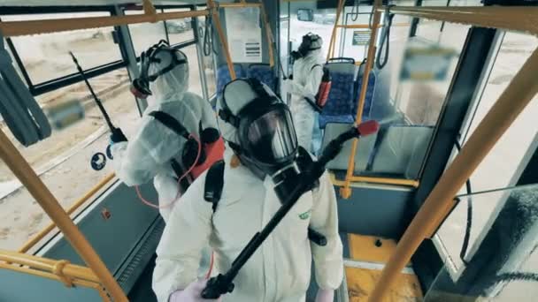 A dolgozók fertőtlenítenek egy buszt a covid-19 járvány idején.. — Stock videók