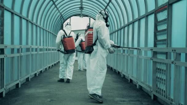 Los trabajadores masculinos desinfectan el paso elevado para limpiarlo del virus . — Vídeos de Stock